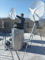 Tim hält auf dem Rehbergturm einen WLAN- Spiegel in der Hand Richtung Sophienberg